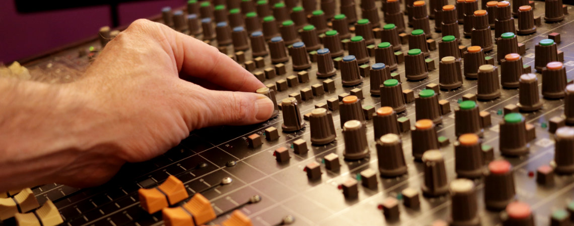 Making adjustments to mixing desk in mixing studio