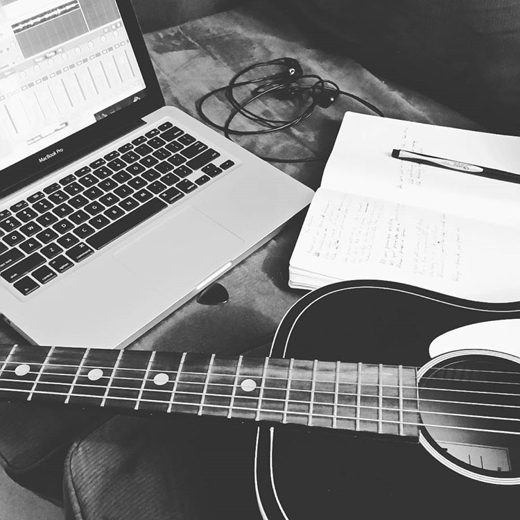 Guitar, computer and notebook for songwriting