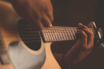 Male songwriter playing acoustic guitar
