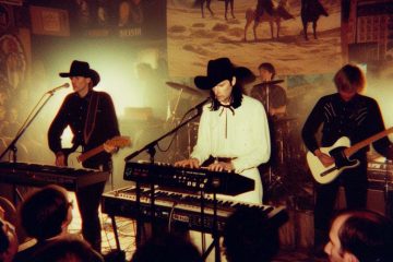 Synth western band performing to a rock crowd